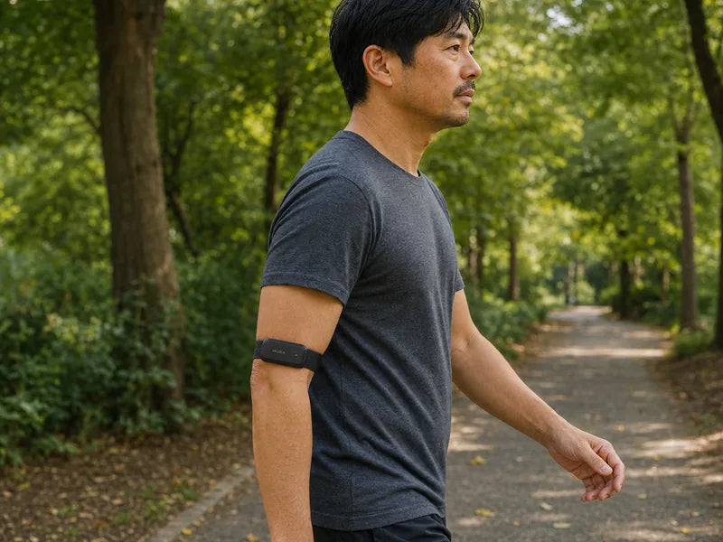 A man wearing a Carbon Mura Band on his upper arm while walking outdoors